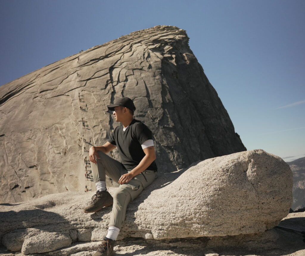 A man sitting at the base of the Half Dome