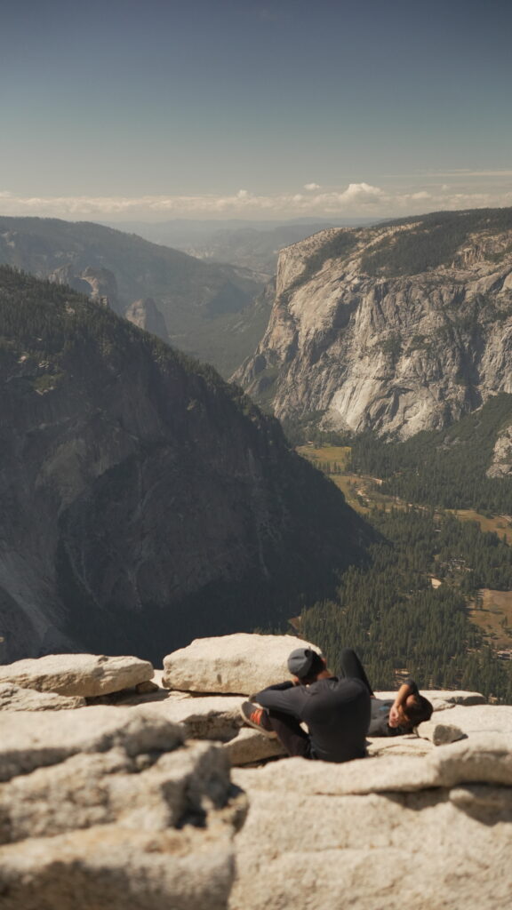 A couple sitting together on the summit of Half Dome